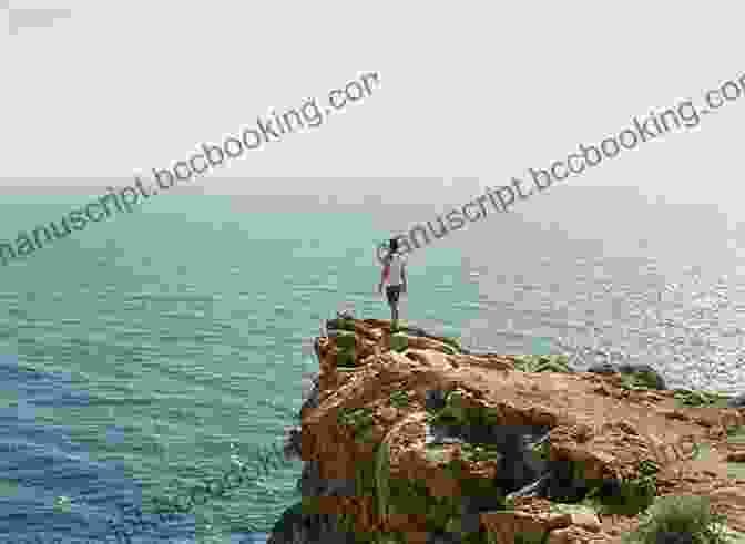A Photo Of A Person Standing On The Edge Of A Cliff, Looking Out At The Vast Ocean Below. Travelling To The Edge Of The World