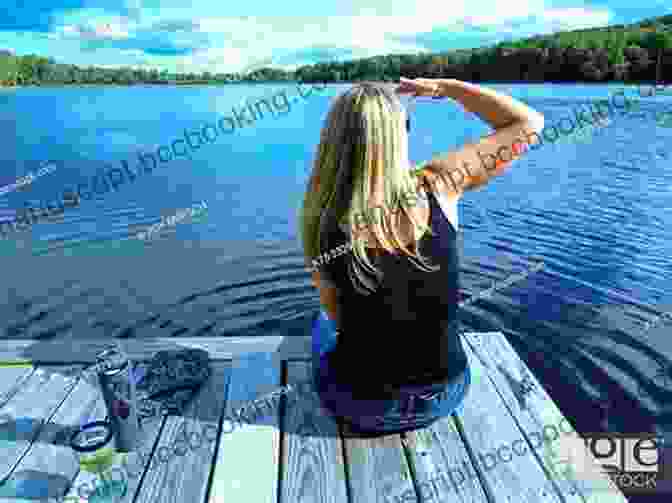 A Woman Sitting On A Dock, Looking Out Over A Tranquil Lake, Surrounded By Lush Greenery. The Summer Cottage Viola Shipman